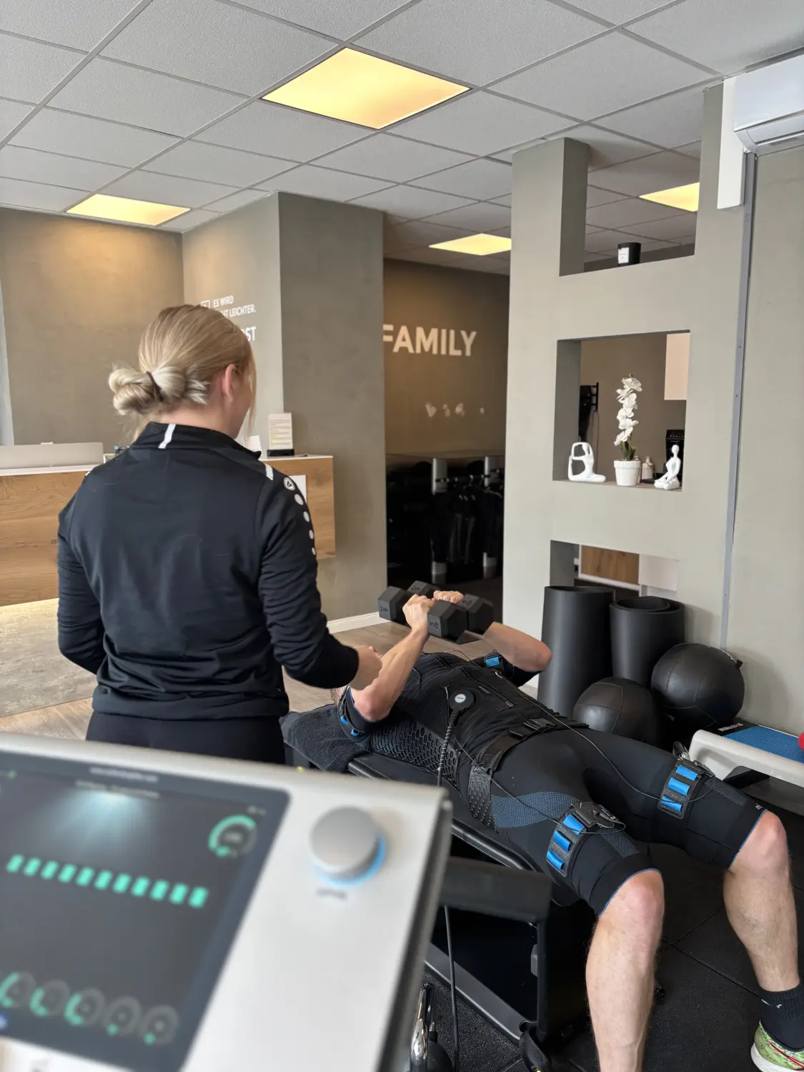 Neopuls EMS Studio - Ausbildung eines Mannes unter Aufsicht einer Ausbilderin